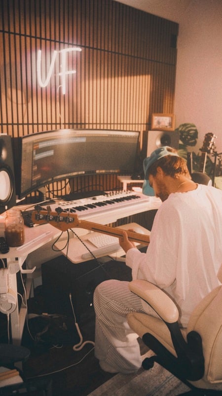 Nick producing at the desk under the neon sign