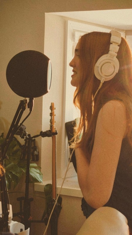 Singer in headphones tracking vocals